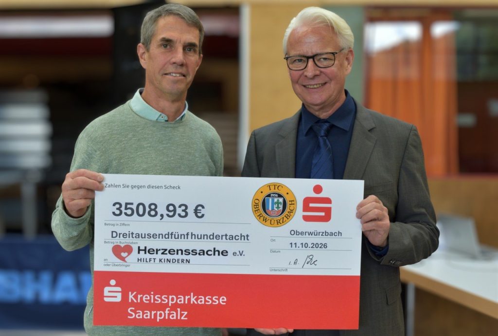 Zwei Männer halten einen großen Spendenscheck über 3508,93 Euro für Herzenssache e.V.